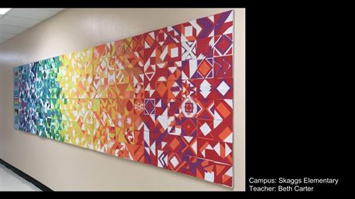 Image shows a large collaborative paper quilt in rainbow color order 